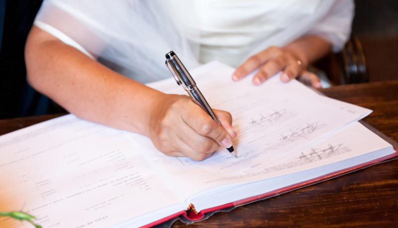 A bride signing in the book at her wedding