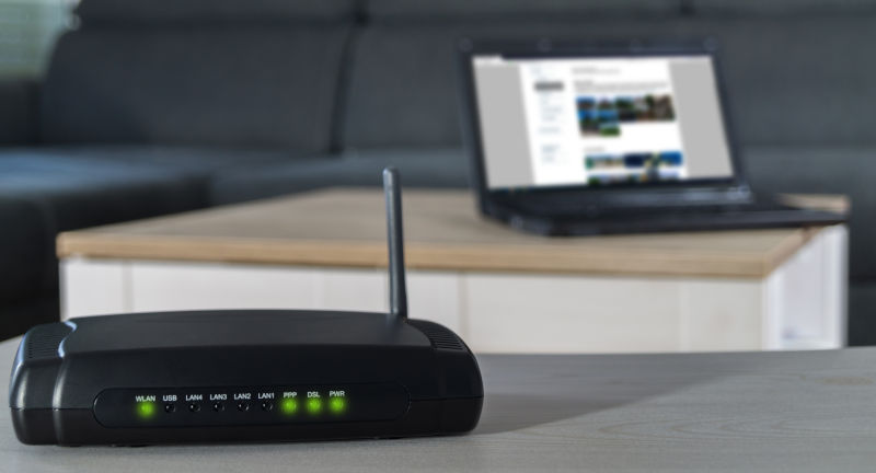 Wifi router in front of a sofa and a laptop