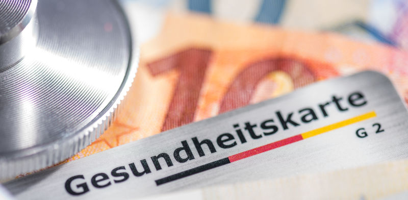 A German health insurance card and a 10.- Euro bill