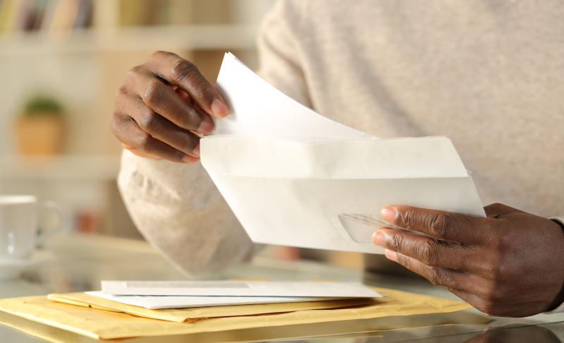A person putting a letter in an envelope