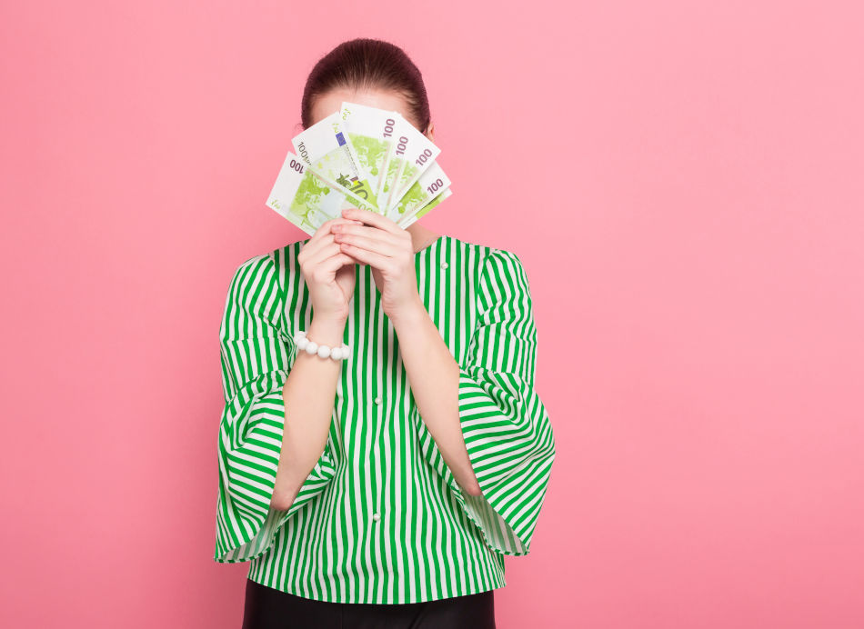 A woman hiding behind banknotes