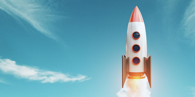 A painted toy rocket starting in front of a blue sky